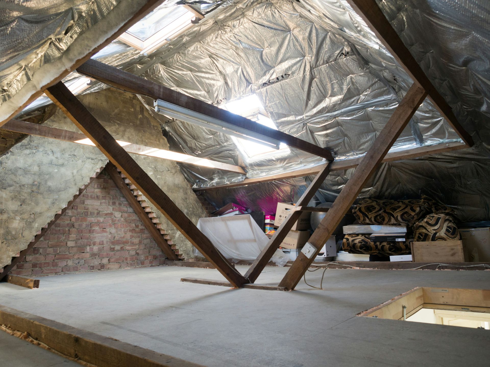 Attic with insulation, beams, and storage