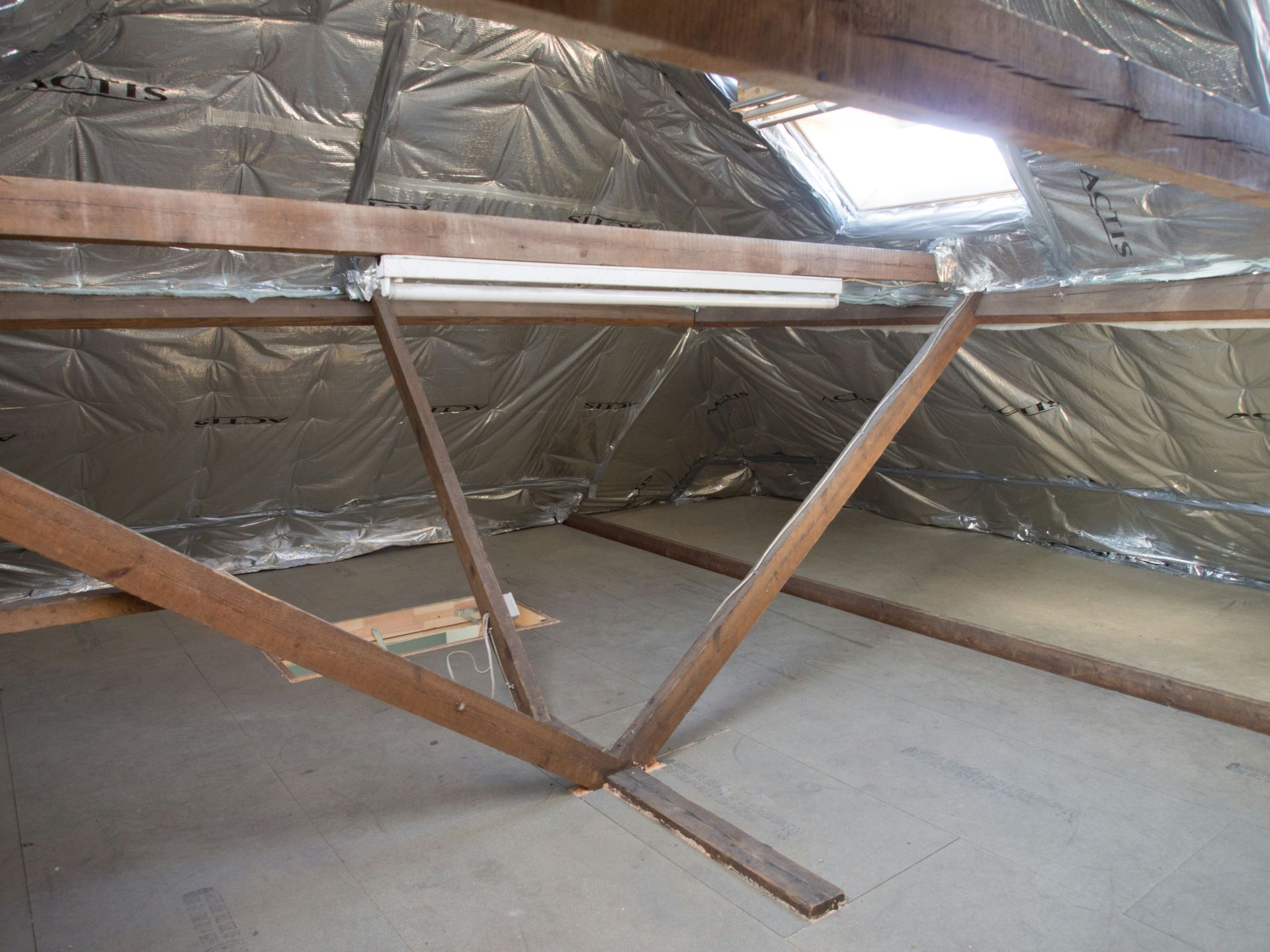 An attic space with insulation and wooden beams